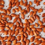 Overhead shot of maple glazed almonds on a baking sheet before being baked.