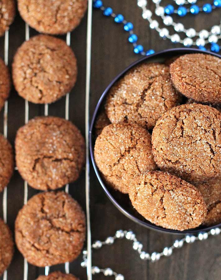 Overhead shot of Vegan Gluten Free Gingerbread Cookies with a rack of more cookies cooling off to the side.