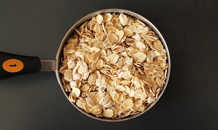 A cup of rolled oats in a measuring cup.