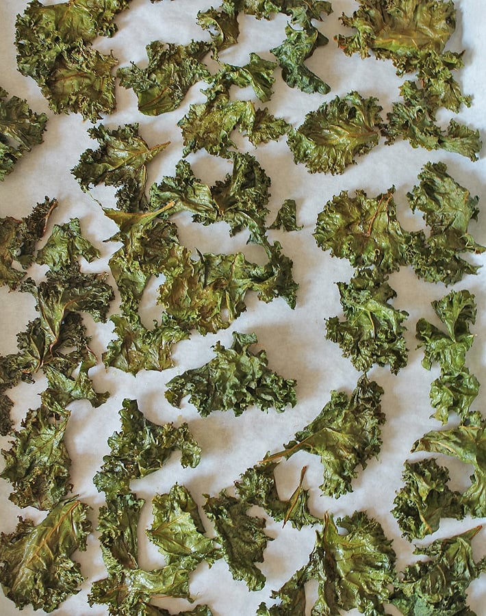 Freshly baked easy kale chips on a baking sheet.