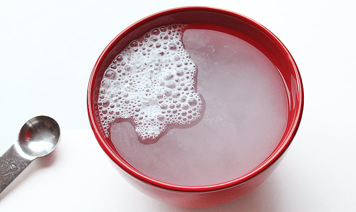 Baking powder bubbling in a bowl of water.