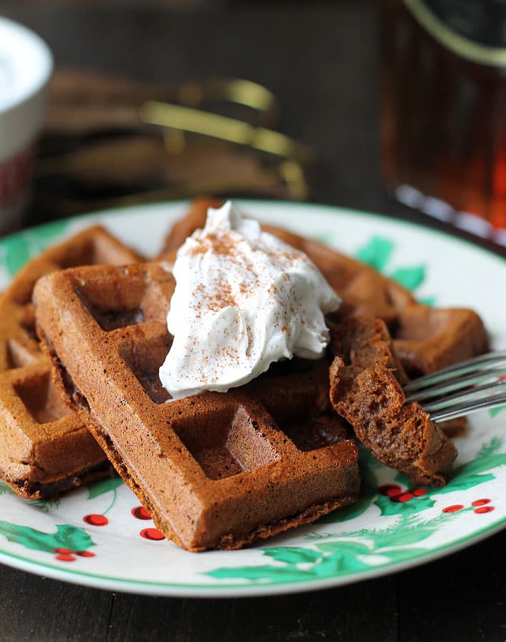 Vegan Gluten Free Gingerbread Waffles on a plate, a fork is taking a piece of the waffle.