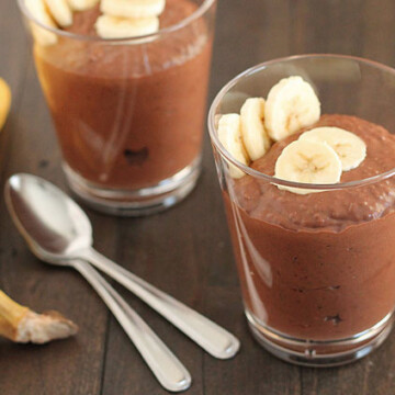 Chocolate Banana Coconut Chia Pudding in two glasses with sliced bananas on top for garnish.