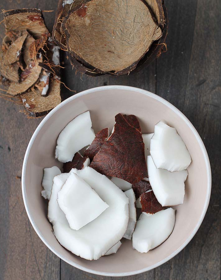 A bowl full of fresh coconut pieces.