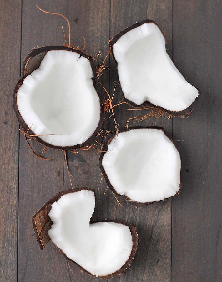 A cracked fresh coconut on a table.