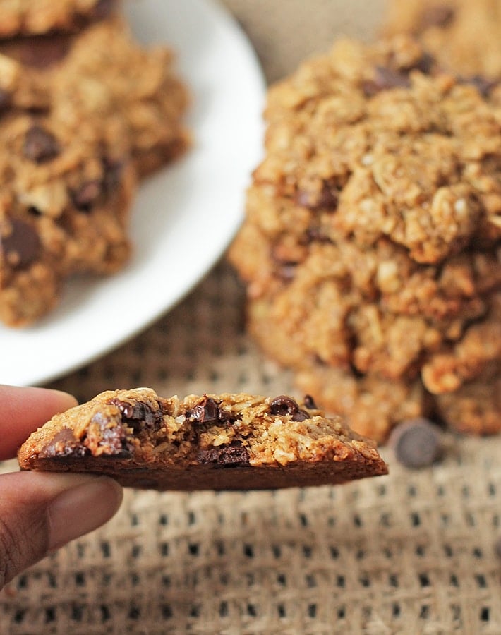 Up close shot of an oatmeal coconut chocolate chip cookie with a bite taken out of it.