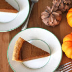 Overhead shot of a slice of quick and easy vegan pumpkin pie on a green and white plate.