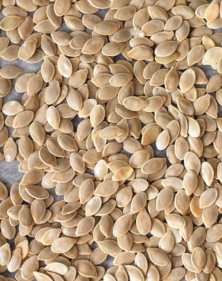 How to Roast Pumpkin Seeds - Rinsed and dried pumpkin seeds on a baking sheet just before being placed in the oven.