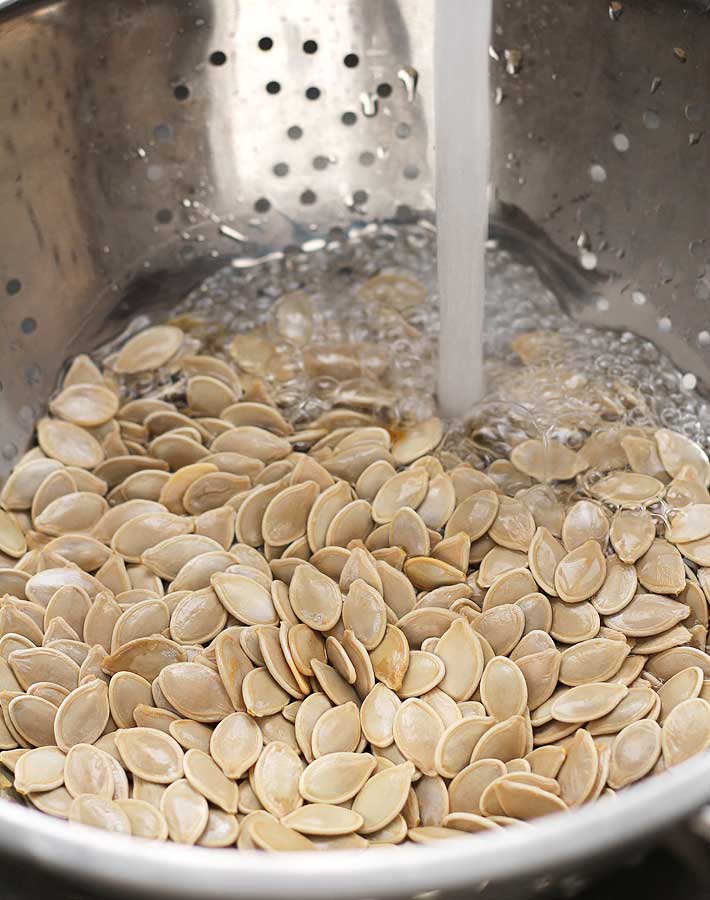 How to Roast Pumpkin Seeds - Fresh pumpkin seeds being rinsed to be roasted.