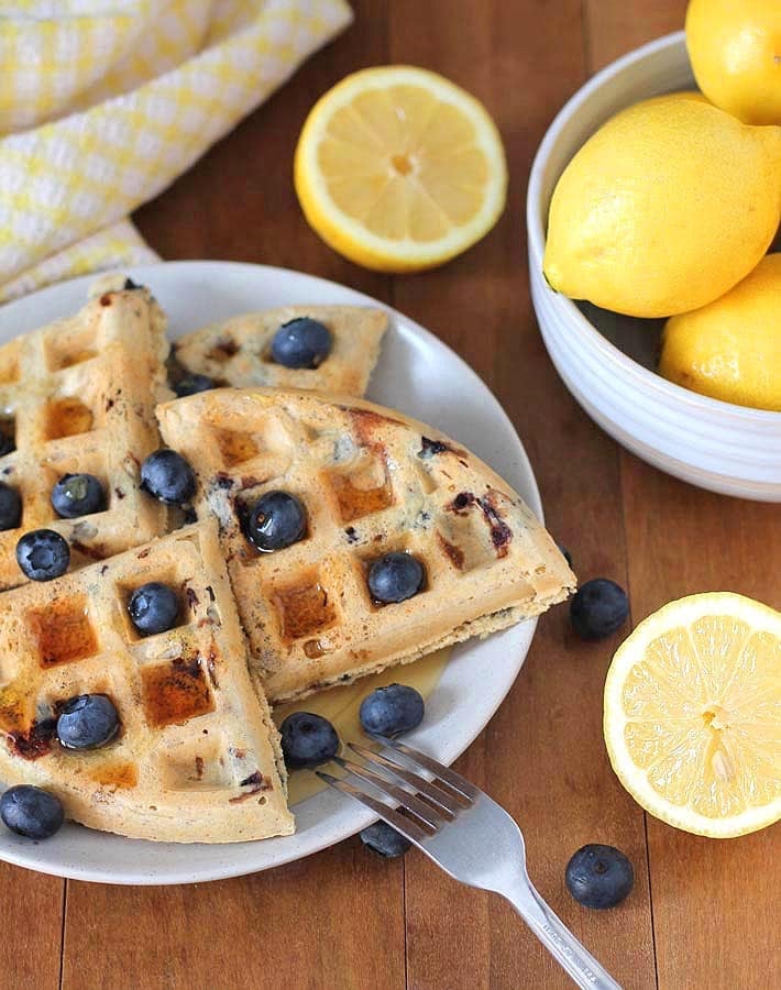 Vegan Gluten Free Lemon Blueberry Waffles garnished with fresh blueberries on a plate.