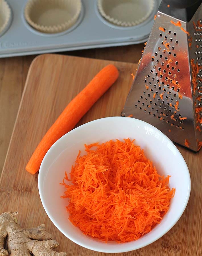 Shredded carrots in a bowl to be used to make Carrot Ginger Muffins.