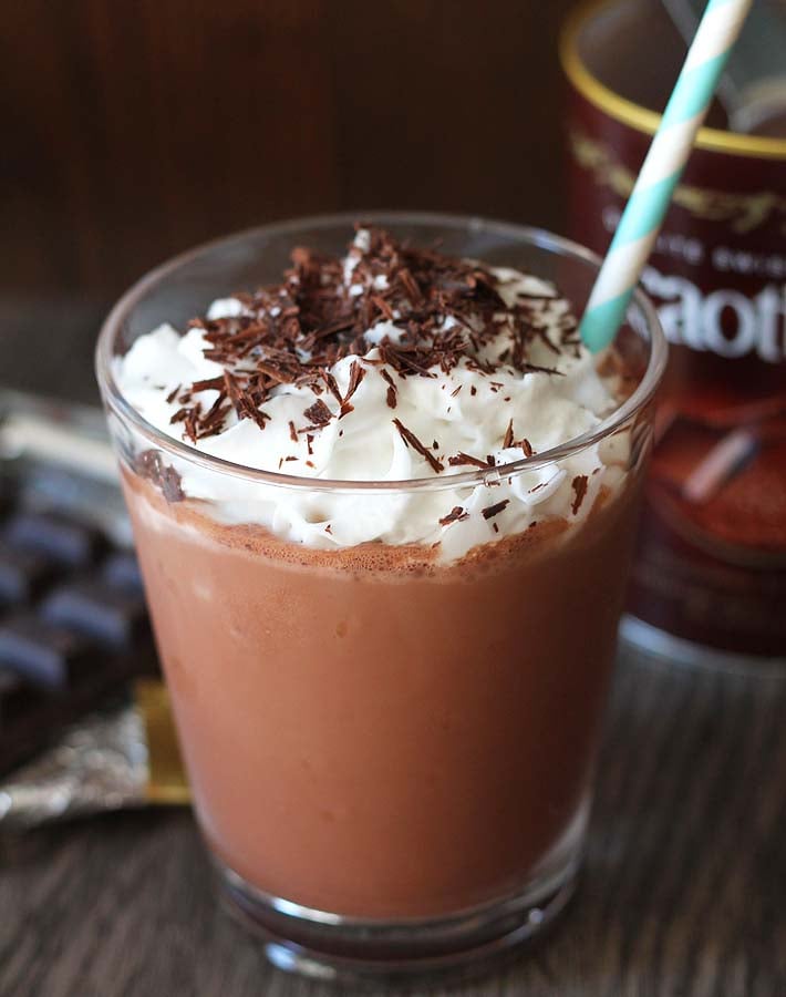 Vegan Mocha Frappe in a glass topped with coconut whipped cream and chocolate shavings.