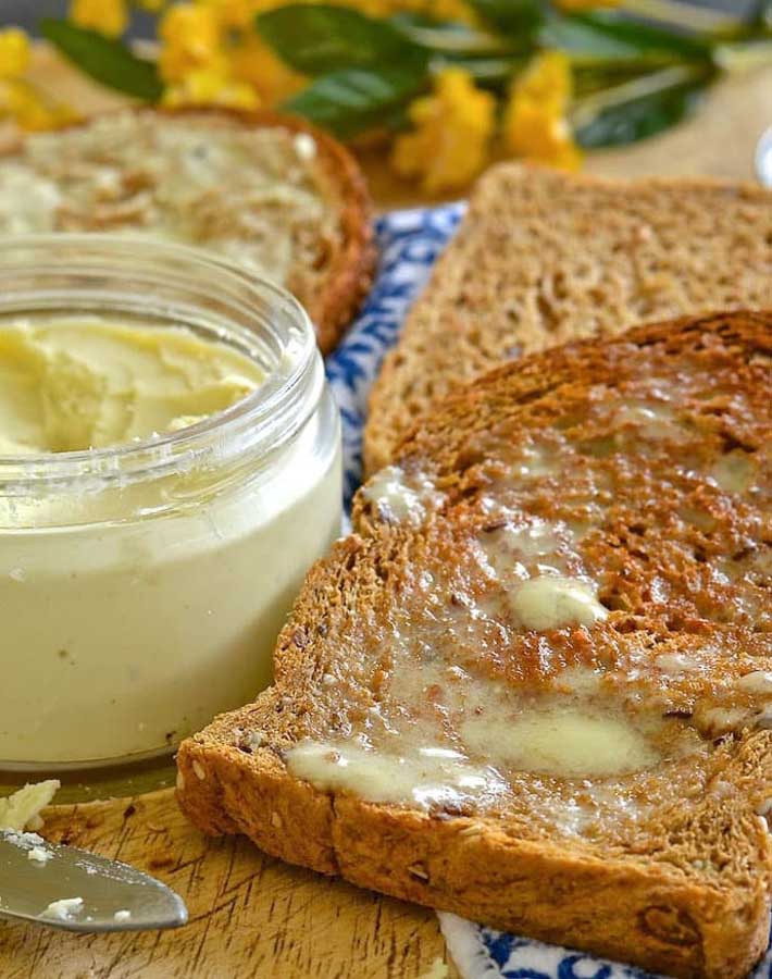 Vegan butter spread onto a piece of toast.