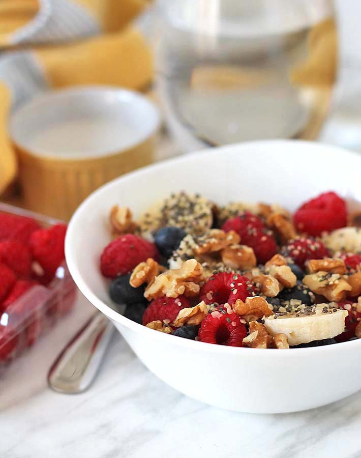 A Berry Coconut Breakfast Bowl sitting on a white marble surface