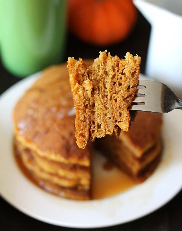 A close up shot of vegan gluten free pumpkin pancakes showing the fluffy insides