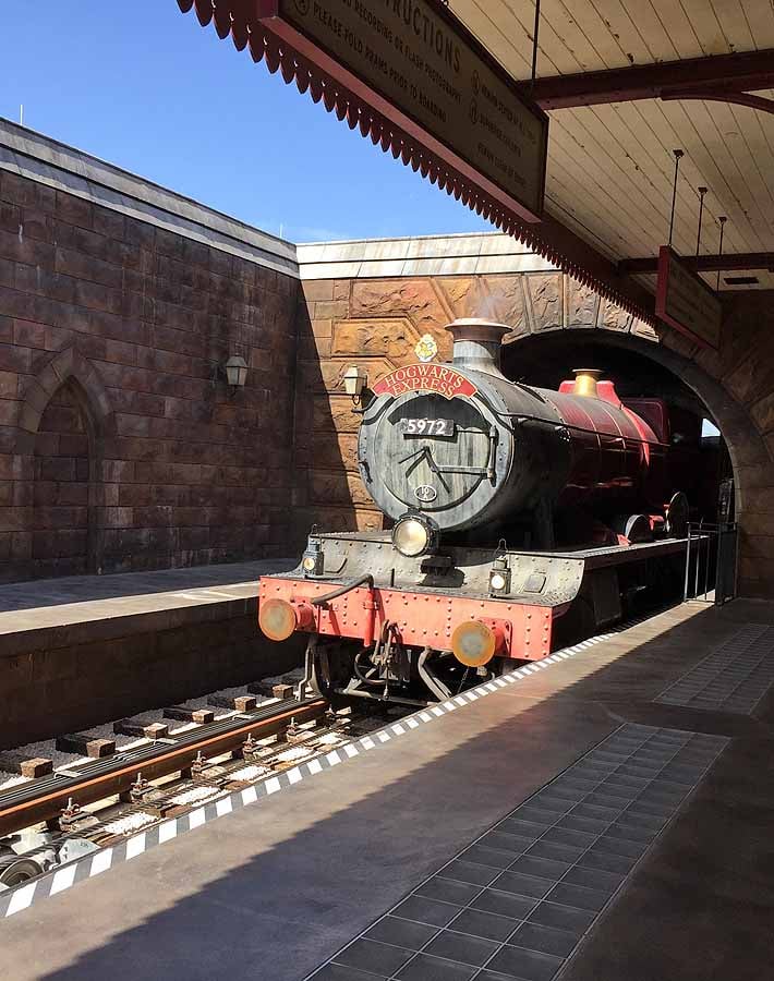 The Hogwarts Express train at Universal Studios Orlando coming out of a tunnel.