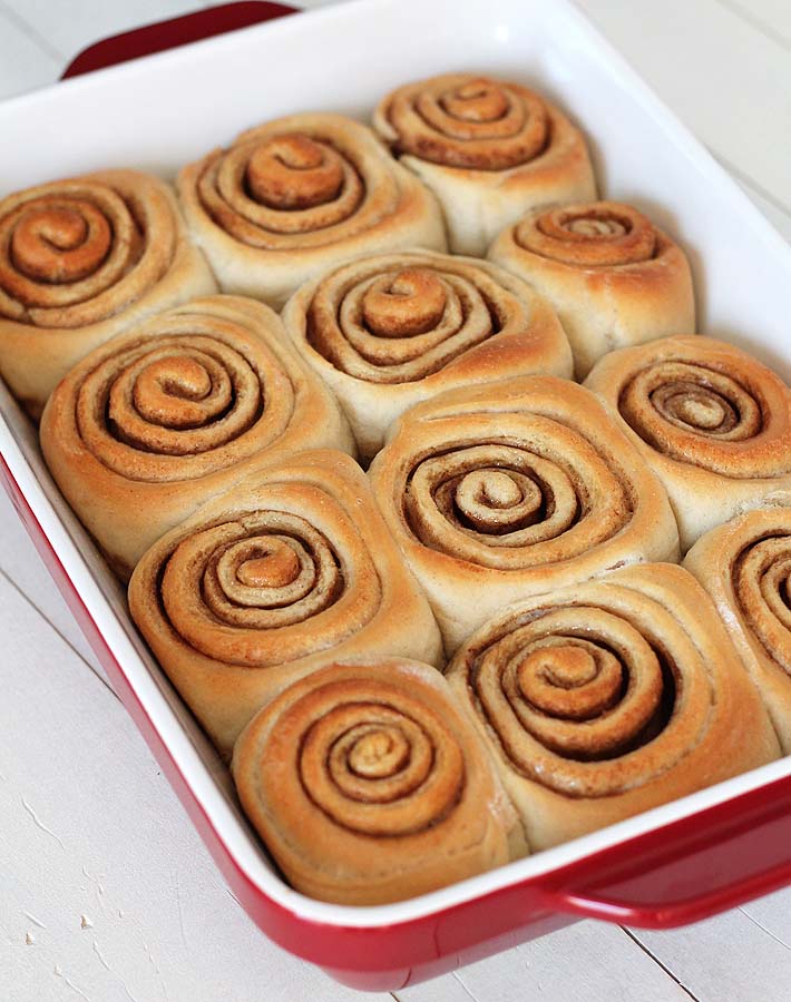 Overhead shot of Easy Vegan Cinnamon Rolls, just out of the oven, in a red baking dish.
