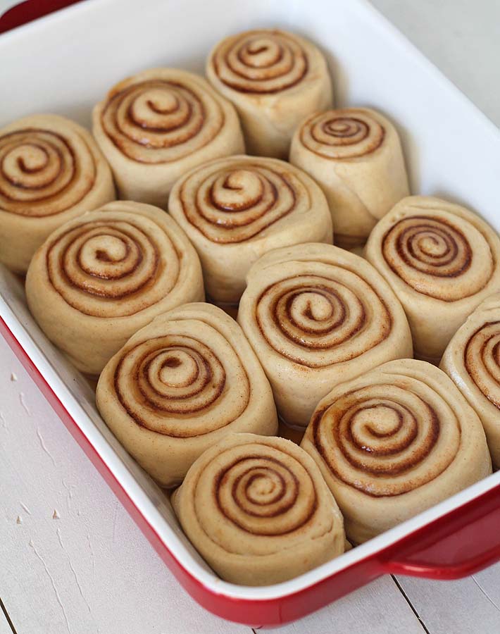 Overhead shot of Easy Vegan Cinnamon Rolls in a red baking dish just as they are about to be put into the oven.