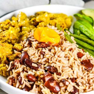 Easy Instant Pot Vegan Recipes - Instant Pot Jamaican Rice and Peas in a white bowl with green beans to the right and curried vegetables to the left.