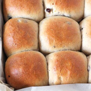 An overhead image of hot cross buns in a pan, fresh from the oven.