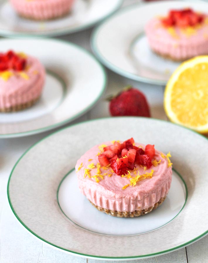 Four Vegan Lemon Strawberry Cheesecake Bites sitting on plates