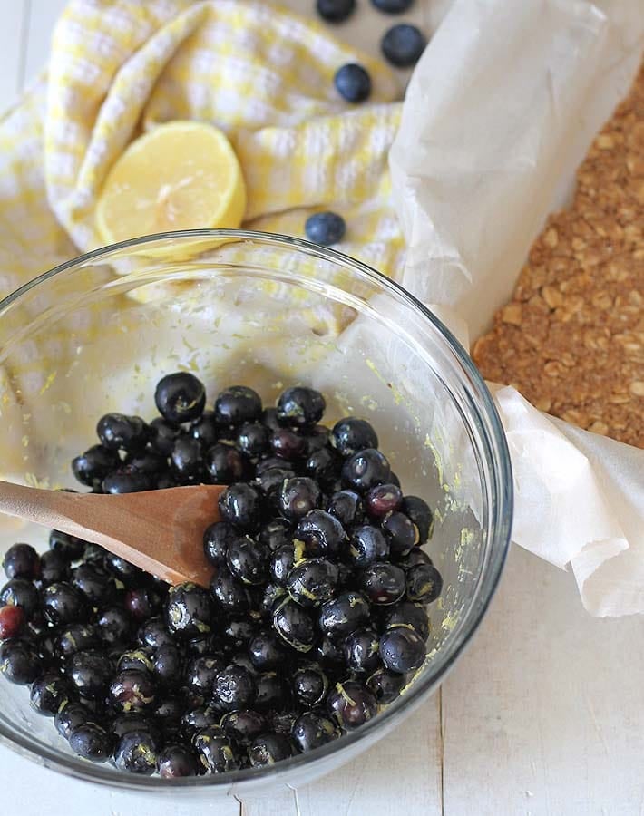 Overhead shot of fresh blueberries ina glass bowl to make the filling for Blueberry Oatmeal Bars.