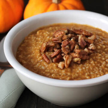 Pumpkin Steel Cut Oats in a bowl topped with chopped pecans.
