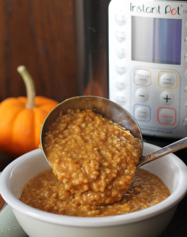 A ladle of Pumpkin Steel Cut Oats being poured into a bowl.