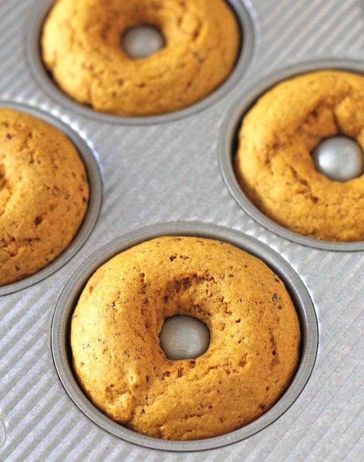Vegan Baked Pumpkin Doughnuts just out of the oven in a doughnut pan.