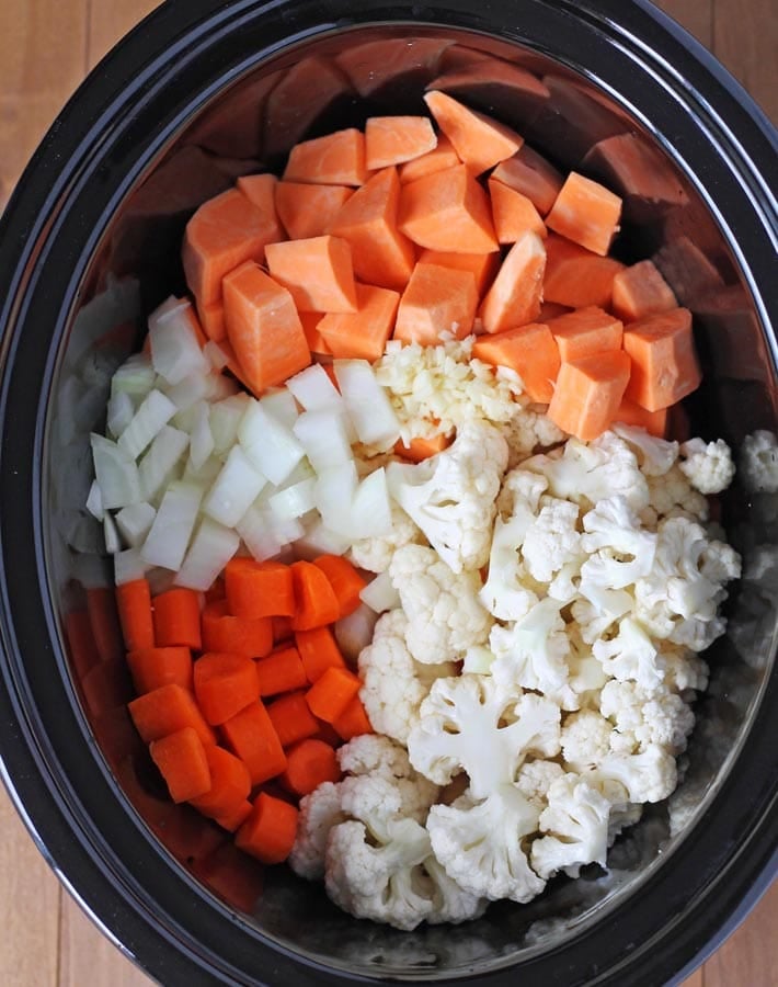 Raw vegetables in slow cooker for Cauliflower Sweet Potato Soup.