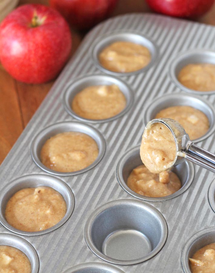 Batter for Gluten Free Vegan Apple Muffins being poured into muffin pan.