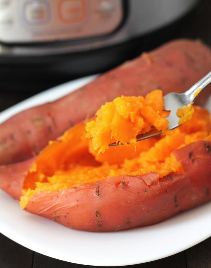 A fork holding a scoop of Instant Pot Sweet Potatoes to show the texture.