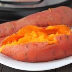 Close up shot of two Instant Pot Sweet Potatoes on a white plate.