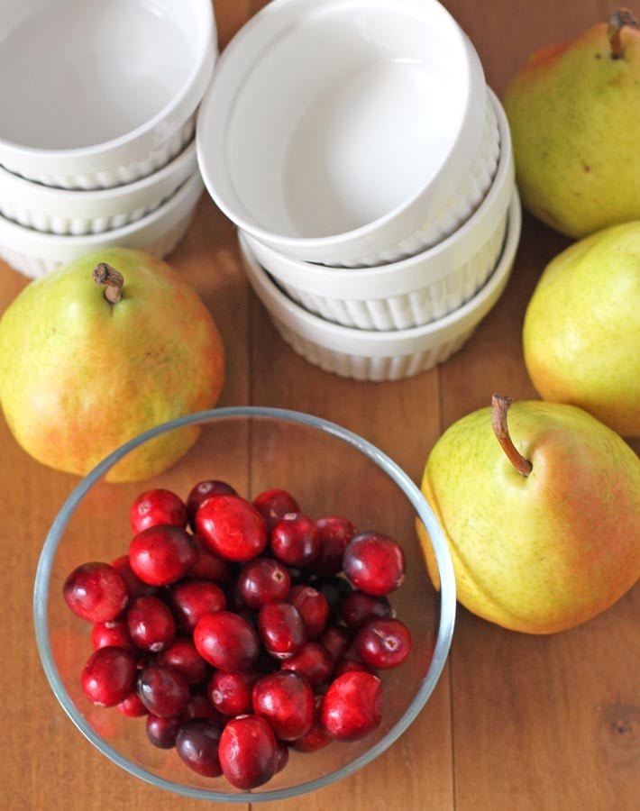 Fresh pears and cranberries on a brown table to make Pear Cranberry Crisp.