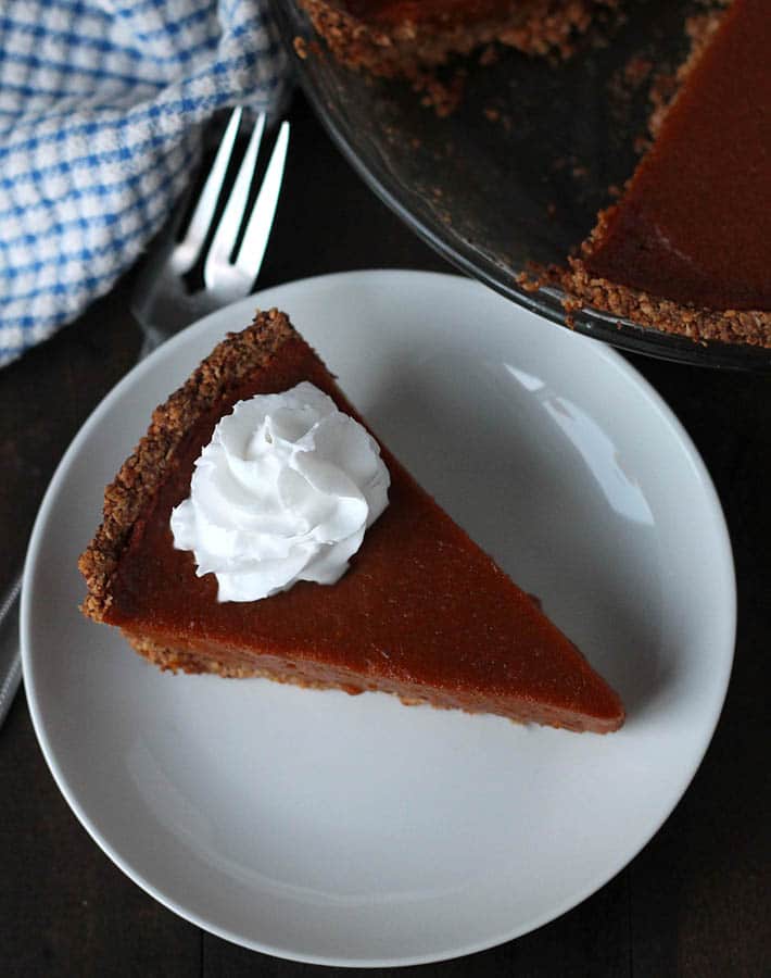 An overhead shot of a slice of Vegan Sweet Potato Pie with whipped coconut cream on top.