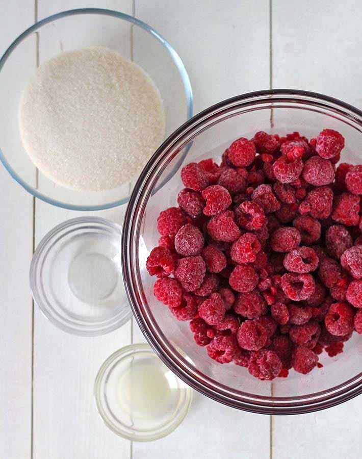 Overhead shot of the ingredients needed to make easy raspberry sauce.