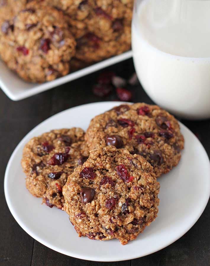 Three Oatmeal Cranberry Chocolate Chip Cookies on a small white plate.