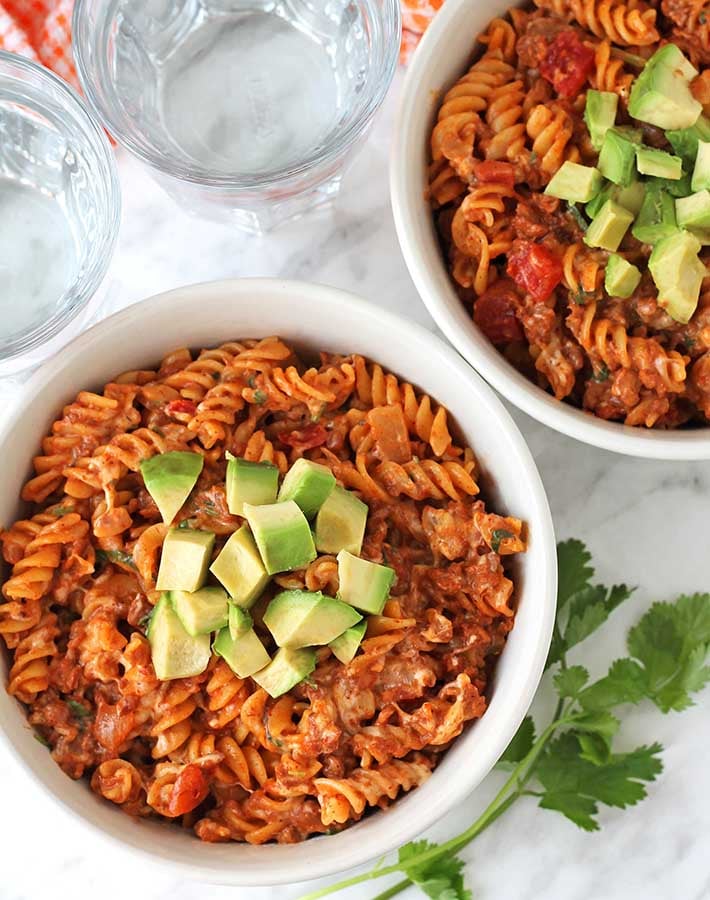 Overhead shot of two bowls of One Pot Cheesy Taco Pasta in white bowls.