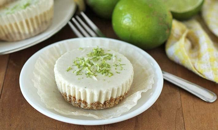 Vegan Lime Cheesecake on a plate, plate sits on a brown wooden table.