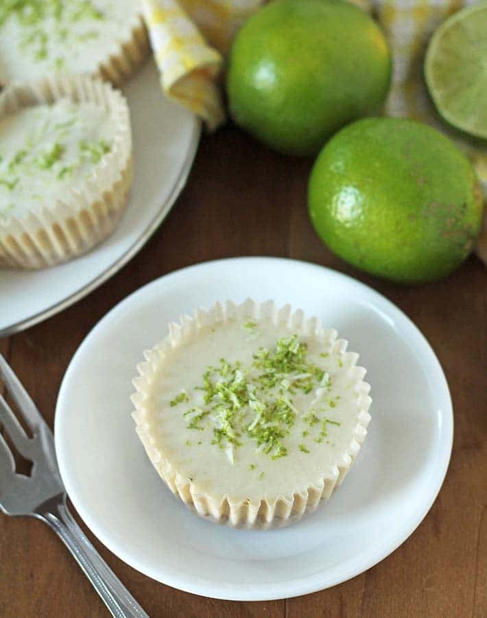 Vegan Lime Cheesecake on a white plate, a fork sits to the left of the plate.