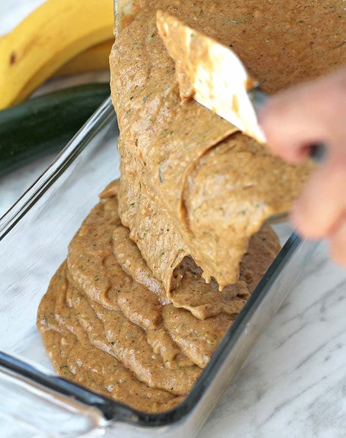 The batter for Gluten-Free Banana Zucchini Bread being poured into a baking dish.