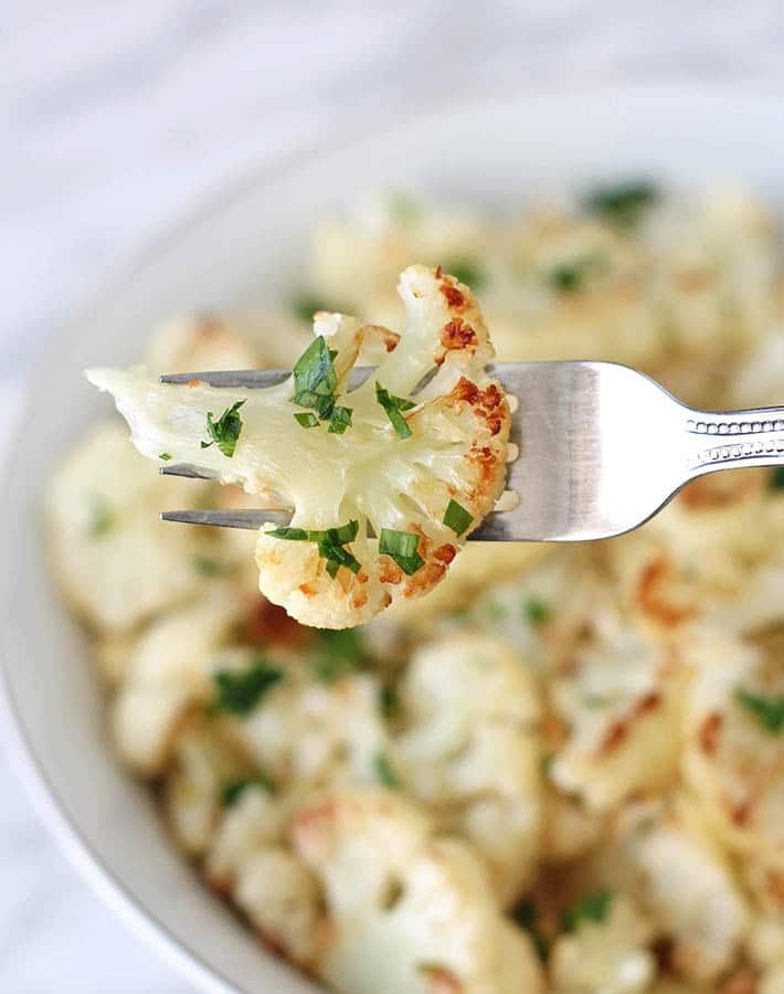 A close-up of a piece of Roasted Garlic Cauliflower on a fork.