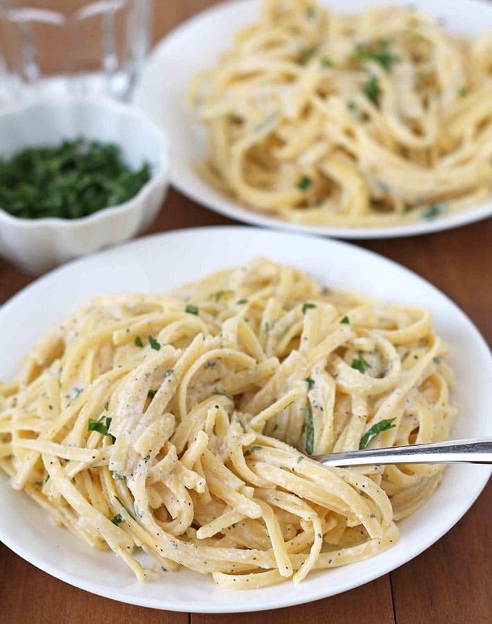 Vegan Garlic Pasta Sauce on a plate, a fork is stuck into the pasta.