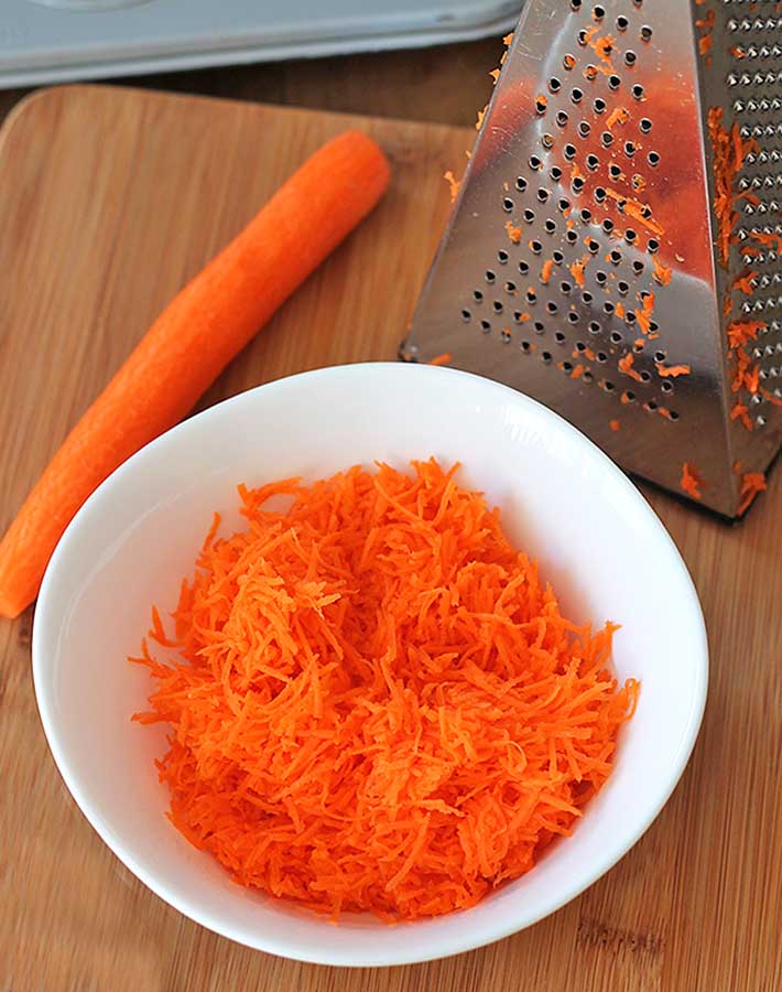 Shredded carrots in a bowl to make carrot coconut muffins.