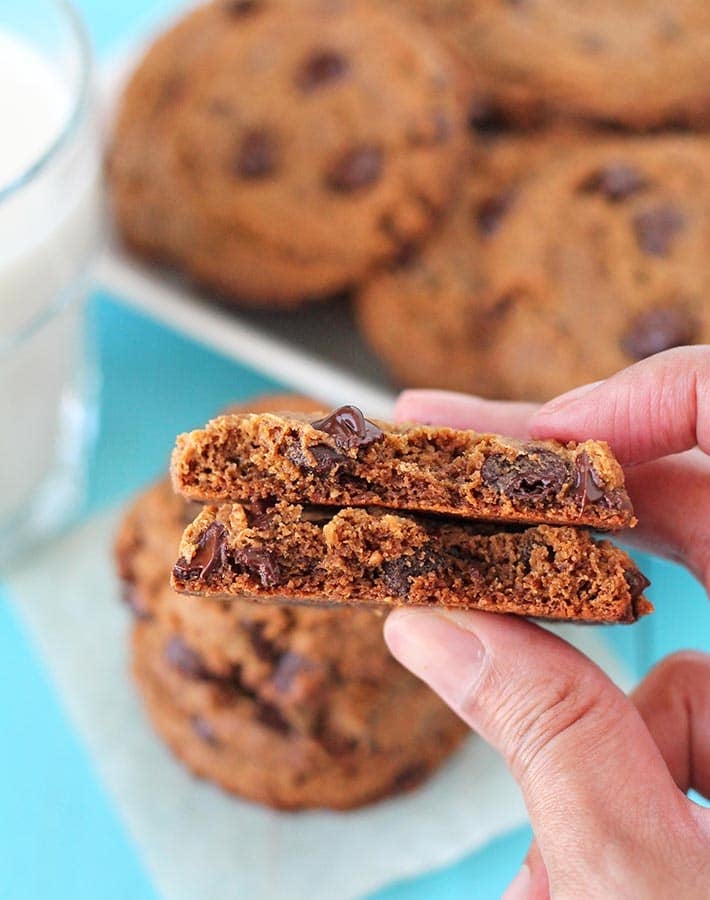 A hand holding a Vegan Gluten Free Peanut Butter Cookies broken in half to show the inner texture.