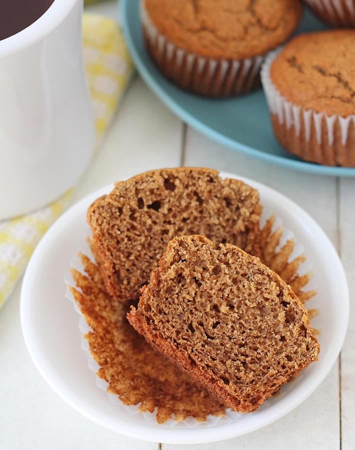 Vegan Gluten Free Banana Muffins on plate, one muffin is in the front and is split in half to show the fluffy interior.