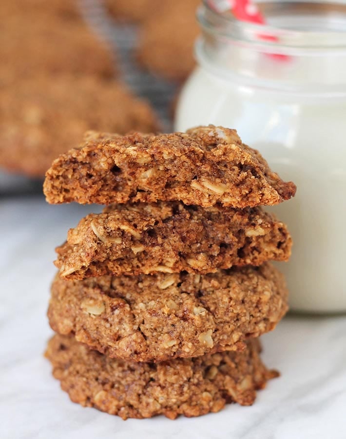 A stack of three eggless oatmeal cookies, the top cookie is split in two to show the inner texture.