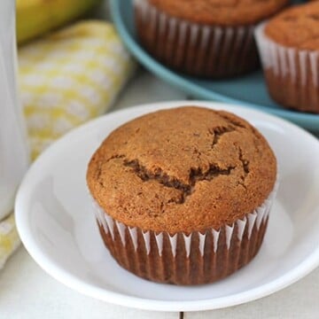 Vegan Gluten Free Banana Muffins on a white table, a cup of tea sits to the left.