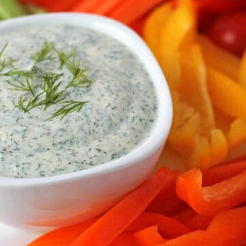 Close up shot of vegan veggie dip in a bowl with fresh vegetables around it.