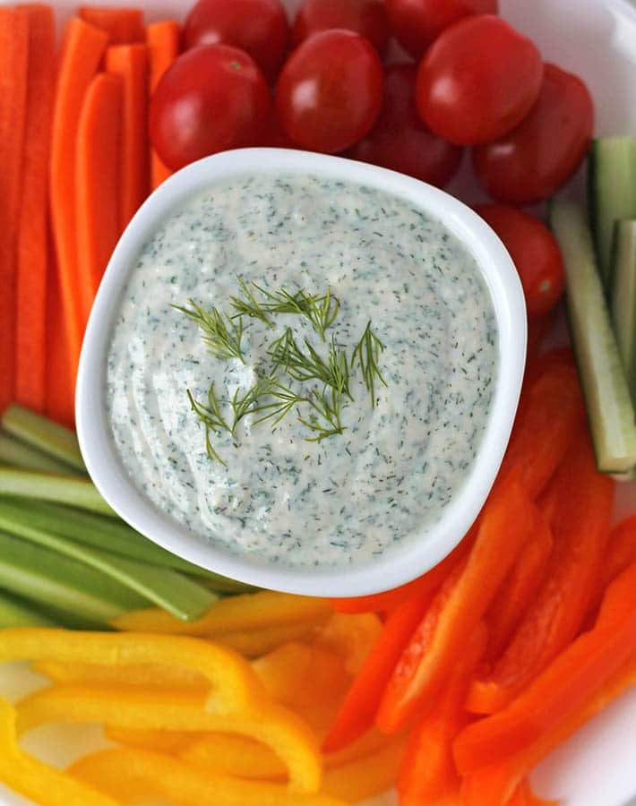 Vegan veggie dip in a bowl, fresh vegetables are around the bowl.